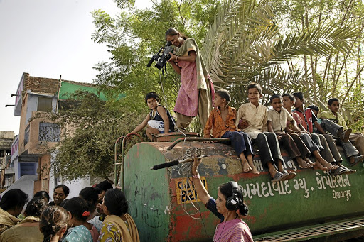 Here in the Muslim area of Juhapura, Ahmedabad, a film crew of two women document chronic water problems. The truck they are standing on visits sporadically, providing families with two buckets of water every 24 hours.