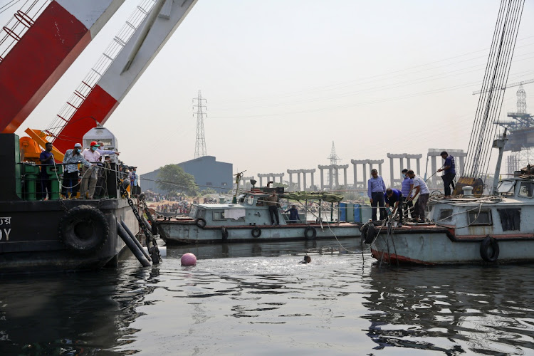 Rescue workers are on duty to rescue the ferry that collided with a cargo vessel and sank on Sunday in the Shitalakhsyaa River in Narayanganj, Bangladesh, April 5, 2021.