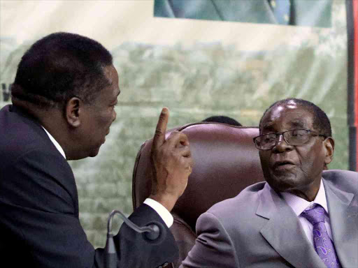 Zimbabwe's President Robert Mugabe speaks to Vice-President of Zimbabwe Emmerson Mnangagwa during a meeting of Central Committee, the decision making body of his ruling Zanu-PF party, in Harare, Zimbabwe, September 9, 2016. /REUTERS