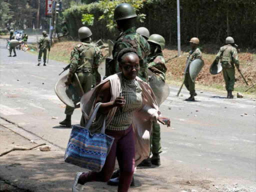 A University of Nairobi student runs as riot policemen disperse students protesting against the detention of Embakasi East MP Babu Owino, September 28, 2017. /REUTERS