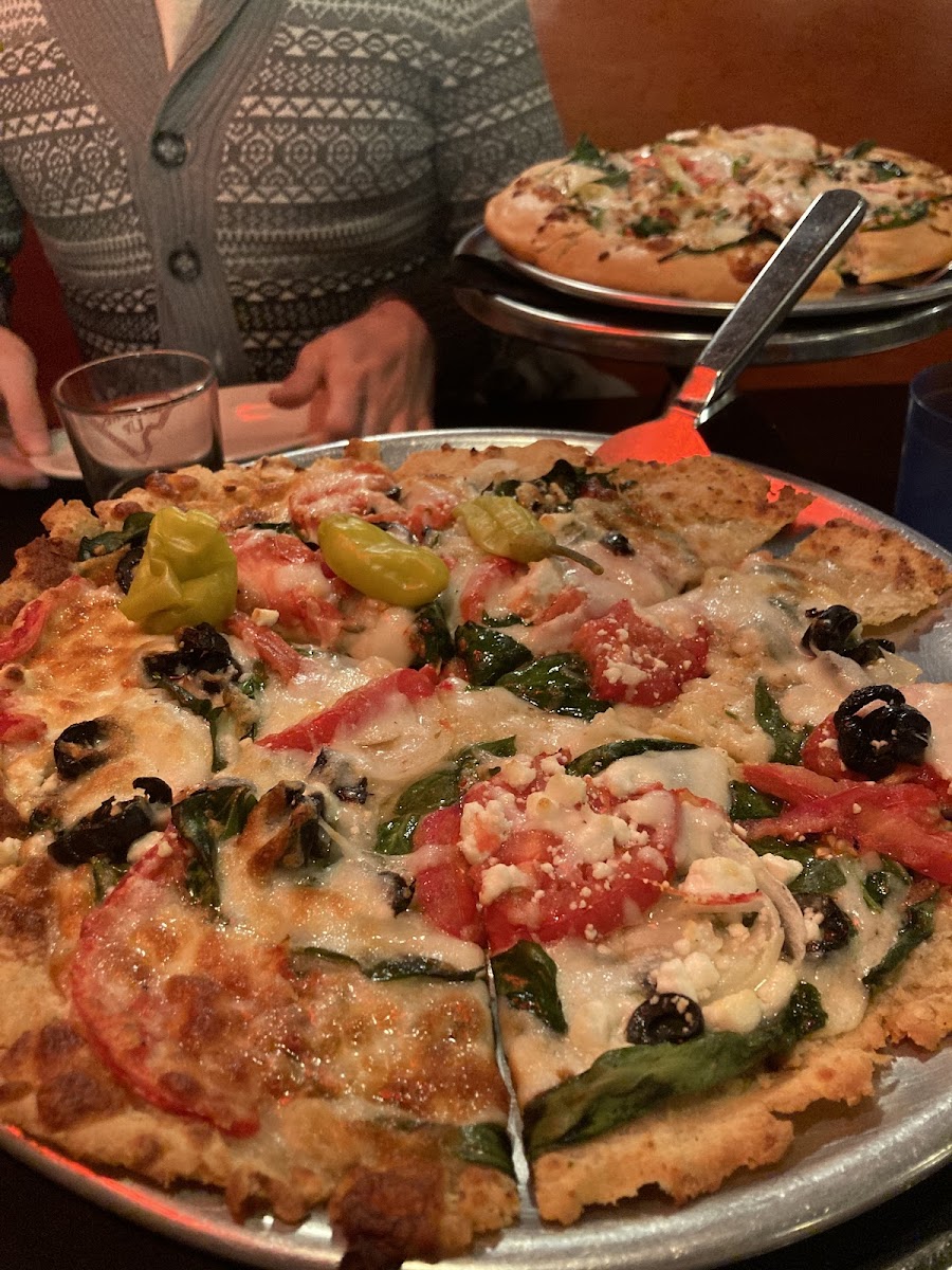Greek pizza (gluten free) in front; standard pizza in the back