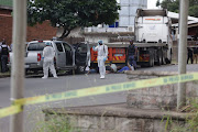 Police inspect the vehicles of five armed men suspected to be hitmen.