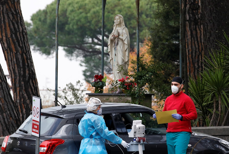 Medical workers tend to patients in cars waiting for treatment outside the Cotugno hospital amid the outbreak of the coronavirus disease in Naples, Italy on November 12 2020.