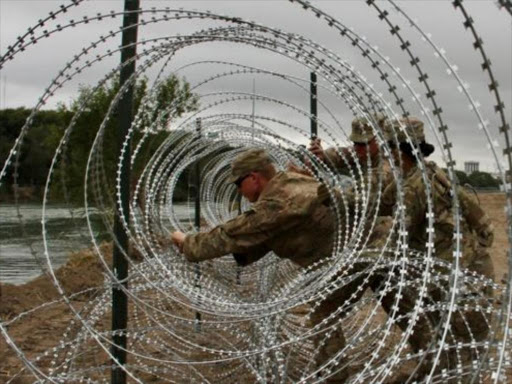 Soldiers are helping to lay miles of razor wire along the border. /BBC