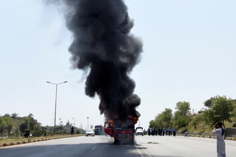 Fire and smoke billows from a bus after it caught a fire during clashes between police and supporters of Pakistan's former prime minister Imran Khan in Islamabad, Pakistan, on Friday. Pictures: REUTERS/STRINGER