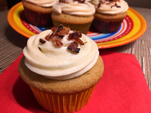 A few cupcakes topped with crumbled bacon.