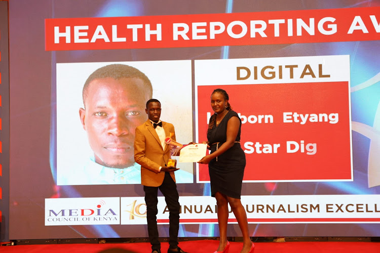 Reporter Hesborn Etyang receiving the award.