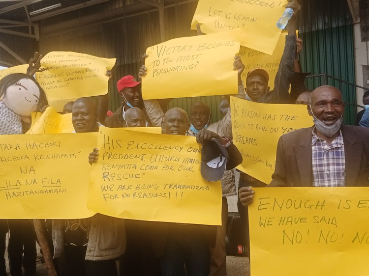 Kirinyaga tea farmers brandishing posters to show their dissatisfaction over a court case filed by previous tea directors in an Embu court.