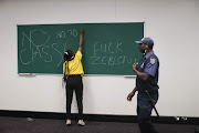 A protesting student writes a message in a classroom after disrupting a lecture at Wits University on Thursday.