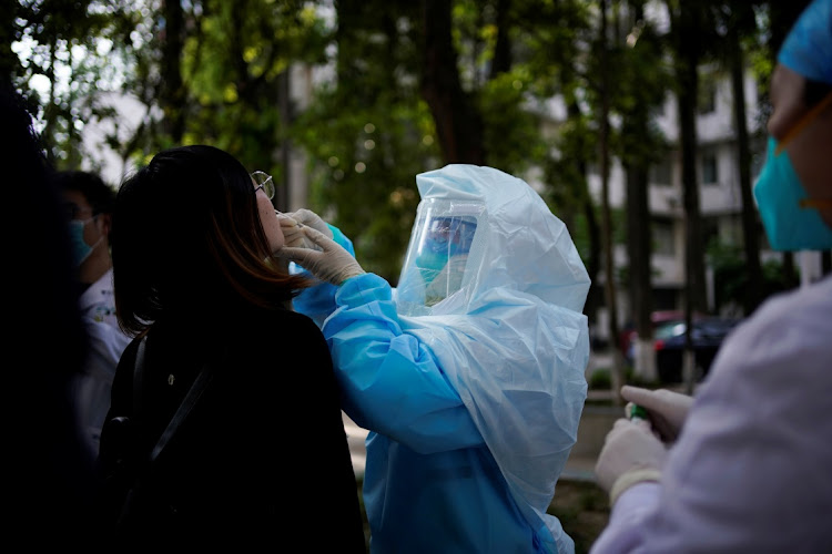 A woman receives a nucleic acid test for Covid-19 on a street near a hospital after the lockdown was lifted in Wuhan, China, on April 13 2020.