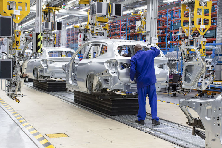 A worker checks the body shell of a BMW X3 on the production line at the BMW Rosslyn plant in Midrand, South Africa.