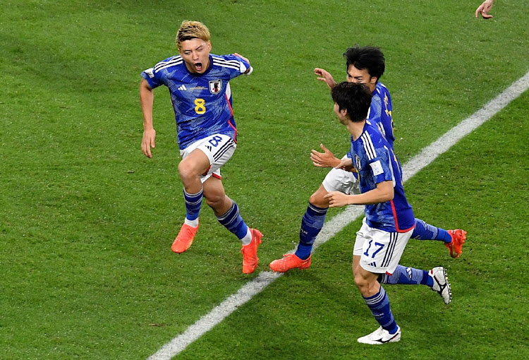 Japan's Ritsu Doan celebrates scoring their first goal with Kaoru Mitoma and Ao Tanaka.