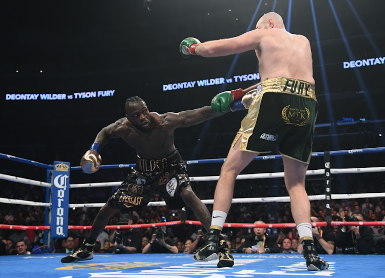 Deontay Wilder jabs Tyson Fury in the first round of their fight in December 2019. The pair are set to faceoff in a rematch on February 2020.