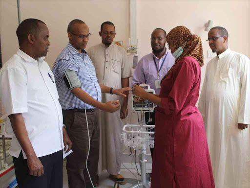 IRA officer Ismail Ahmed (2nd Left) gets his blood pressure checked using one of the four patient monitors they donated to the Garissa Referral Hospital /STEPHEN ASTARIKO