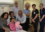 Abongile Ndlovu (foreground) at Netcare uMhlanga Hospital shortly before her discharge. She is pictured with (from left to right) paediatrician, Dr Javeni Govender; her mother, Mrs Prudence Ndlovu; Netcare uMhlanga Hospital general manager, Marc van Heerden; her father, Mr Isaiah Ndlovu; paediatrician, Dr Raj Naranbhai; principal clinical manager of the hospital’s emergency department, Dr Bianca Visser and emergency department nursing sister, Demi du Toit