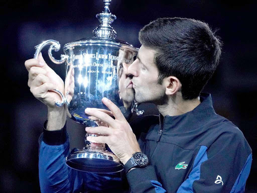 Novak Djokovic of Serbia kisses the U.S. Open trophy after beating Juan Martin del Potro