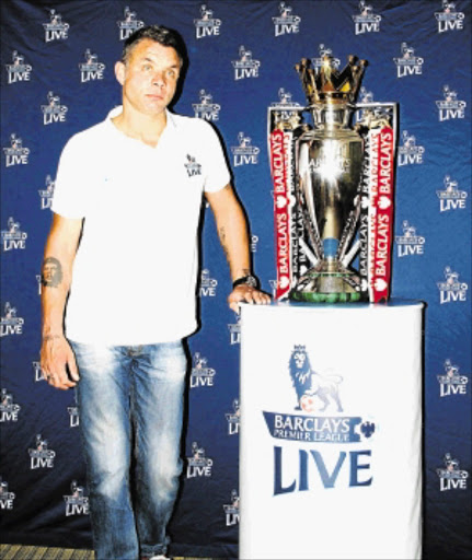 PRIZED CATCH: Mark Fish standing next to the Premier League trophy PHOTO: Anele Nandipha Vabaza