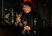 Bong Joon Ho poses with the Oscars for 