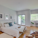 Master Bedroom with white oak hardwood flooring and windows looking out to the backyard