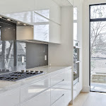 White cabinetry and gray high glass backsplash in a new modern kitchen