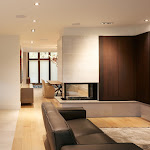 Living area with a three sided fireplace looking into the dining room with white oak flooring