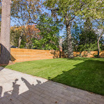 Backyard with stone interlocking and grass ladnscaping