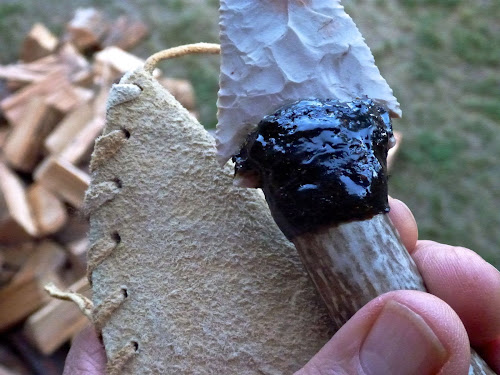 Attaching a chipped blade to an antler handle. The brain-tanned hide serves as the sheath.