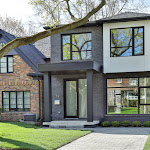 Front of house showing landscaping, stone interlocking, and modern glass front door