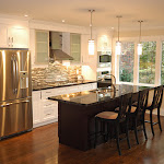 Open concept kitchen with stainless steel appliances and back splash
