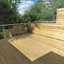 New wooden deck with privacy wall and glass railing