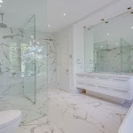 Master bathroom with glass enclosed walk-in shower and wall to floor tiles