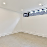 Basement bedroom with window looking out to the driveway