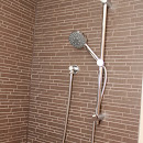 Shower area finished with light brown ceramic tiles