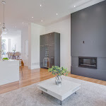 Modern Fireplace in the living room with wine freezer, that is surrounded with grey cabinetry