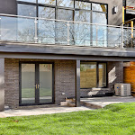 Back of house showing landscaping, stone interlocking, and walkout basement door