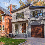 Front view of house outlining landscaping, stone interlocking, and a glass railing on front porch