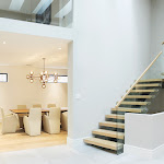 Entrance area leading into the dining room with a modern staircase that has a glass railing