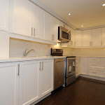 Kitchen renovated with White Kitchen Cabinets / Hardwood Floor and Ceiling Lights