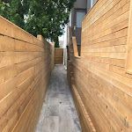 Side of house passage with stone interlock and wooden fence