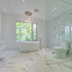 Master bedroom with freestanding bathtub and a window looking out to the backyard