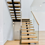 Modern staircase with glass railing and white oak railing