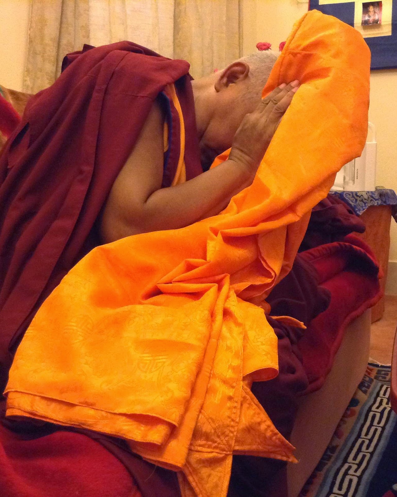 Lama Zopa Rinpoche blessing robes before they are offered to Buddha statue in Mahabodhi Temple, Bodhgaya.