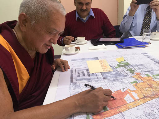 Lama Zopa Rinpoche looking over plans for Maitreya Buddha Kushinagar Project, Delhi, January 2015. Photo by Ven. Roger Kunsang.