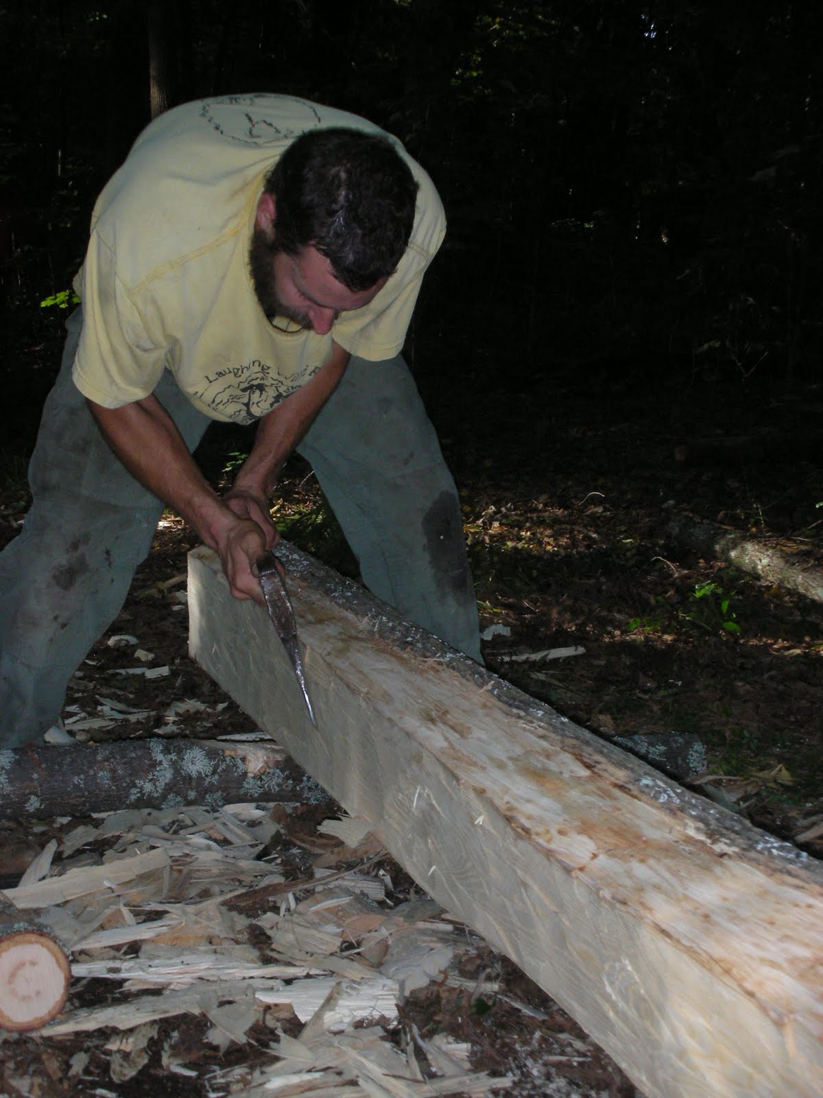 Michael Cuba puts the finishing touches on a log joist.