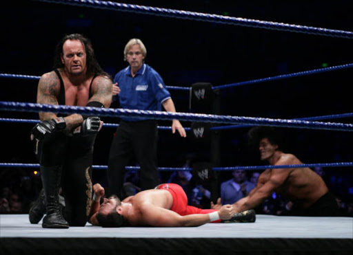 The Undertaker (L) celebrates his victory during the WWE Smackdown at Acer Arena June 15, 2008