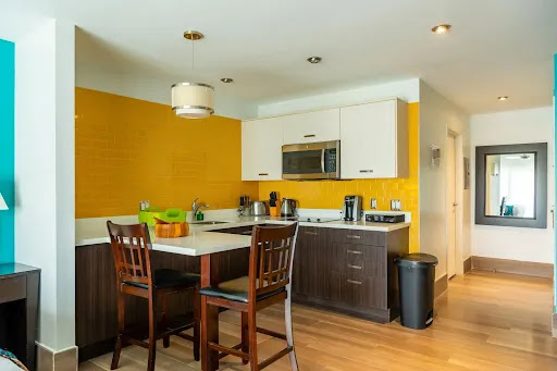 Modern kitchen with counter, stools, and yellow walls in this luxury villa for sale in Lucas ($395,000)