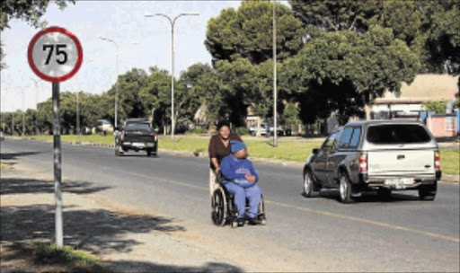 daily struggle: Memesi Pholwane pushes her son, Karabo, 15, who is wheelchair-bound and mentally disabled to catch the bus to school PHOTO: Baleseng Mosotho