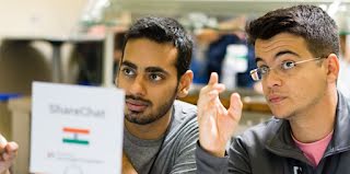 Two guys discussing something in front of laptop.