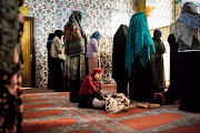 Children fall asleep while women pray the first Taraweeh (late night) prayer of the Muslim holy month of fasting, Ramadan, at the Nizamiye Mosque in Johannesburg on May 26, 2017. The prayer takes place every night for the duration of the 30 day of fasting and many mosques complete a reading of the entire quran in this time. It is believed that Ramadan is when the Quran was first revealed to the Prophet Muhammed (PBUH) by God. The mosque was completed in 2012 and is an adaption of the 16th-century Ottoman Selimiye Mosque which is situated in Erdine, Turkey and it, including the school, museum and shopping complex situated in Midrand is a significant marking of the Turkish community's contribution to the South African landscape.