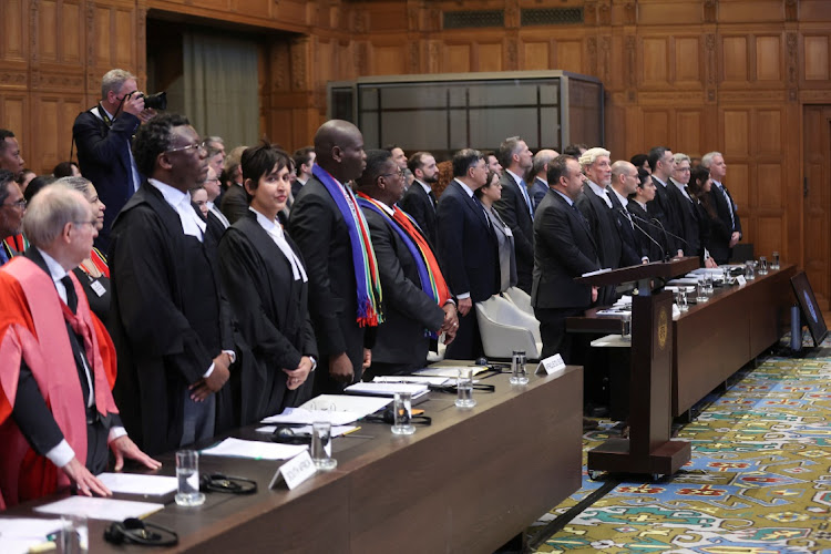 The South African delegation stands as judges at the ICJ on Thursday prepare to hear the country's request for the court to order Israel to stop its military actions in Gaza and to desist from what South Africa says are genocidal acts committed against Palestinians.